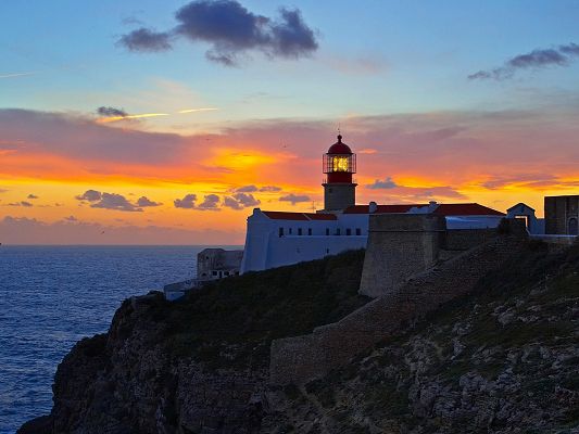 Image of Natural Landscape, Golden Lighthouse, the Setting Sun, the Peaceful Sea 