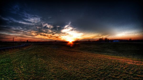 Images of Natural Scenes - The Setting Sun, a Field of Green Grass, the Sky is Getting Dark