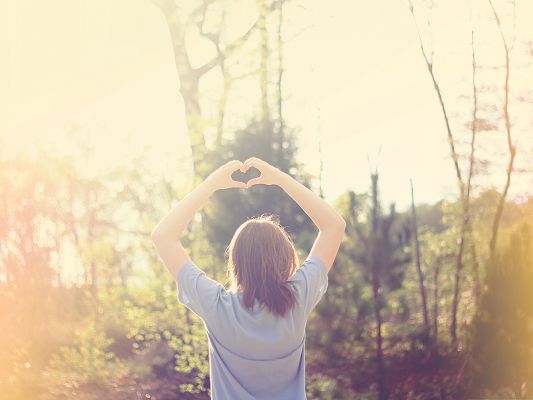 click to free download the wallpaper--Beautiful Girl Outdoor, Making a Heart Pose, Warm Sunshine Embracing Her