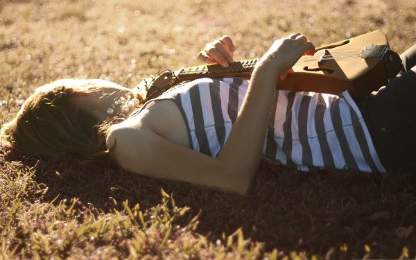 click to free download the wallpaper--Musician Girls Image, Lying on Green Grass, She is Artistic and Beautiful