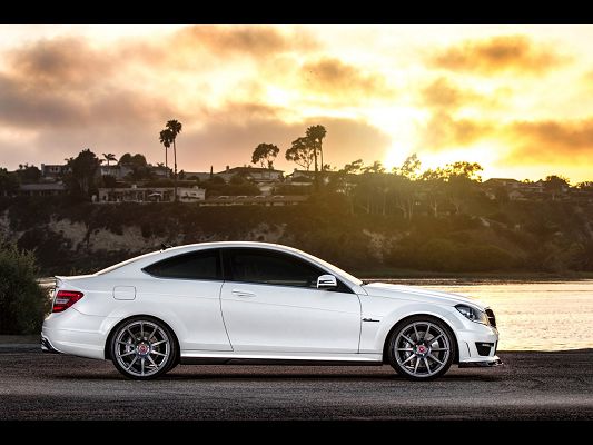click to free download the wallpaper--Super Car Images of Mercedes-Benz C63, a White Car in Front of the Sea, the Golden Sky
