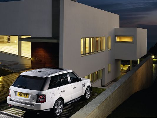 Top Car as Background, White Range Rover Car Next to the Lighted House